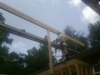 Carpenter setting a ridge beam over a new addition frame — Ice Dam Removal by Roofing Brothers in Kingston Mines