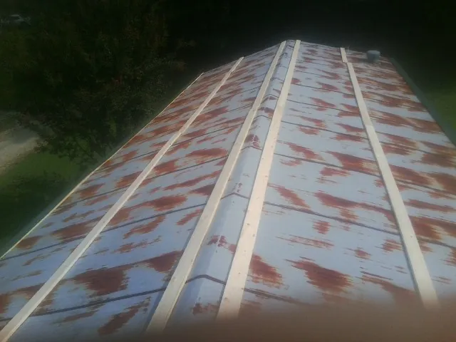 Rusted metal roof panels with new wood purlins before replacement — Storm Damage Roof Repair in Kingston Mines by Roofing Brothers