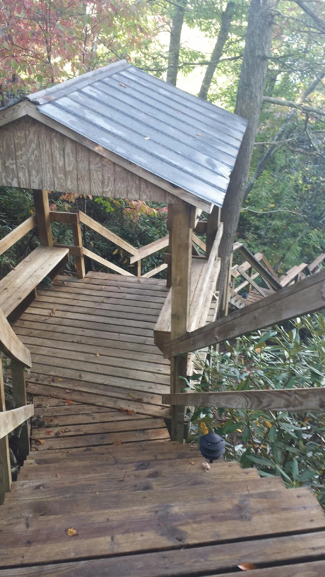 Metal roofed shelter over wooden steps on a wooded walkway — Skylight Repair & Installation work by our crew in Kingston Mines
