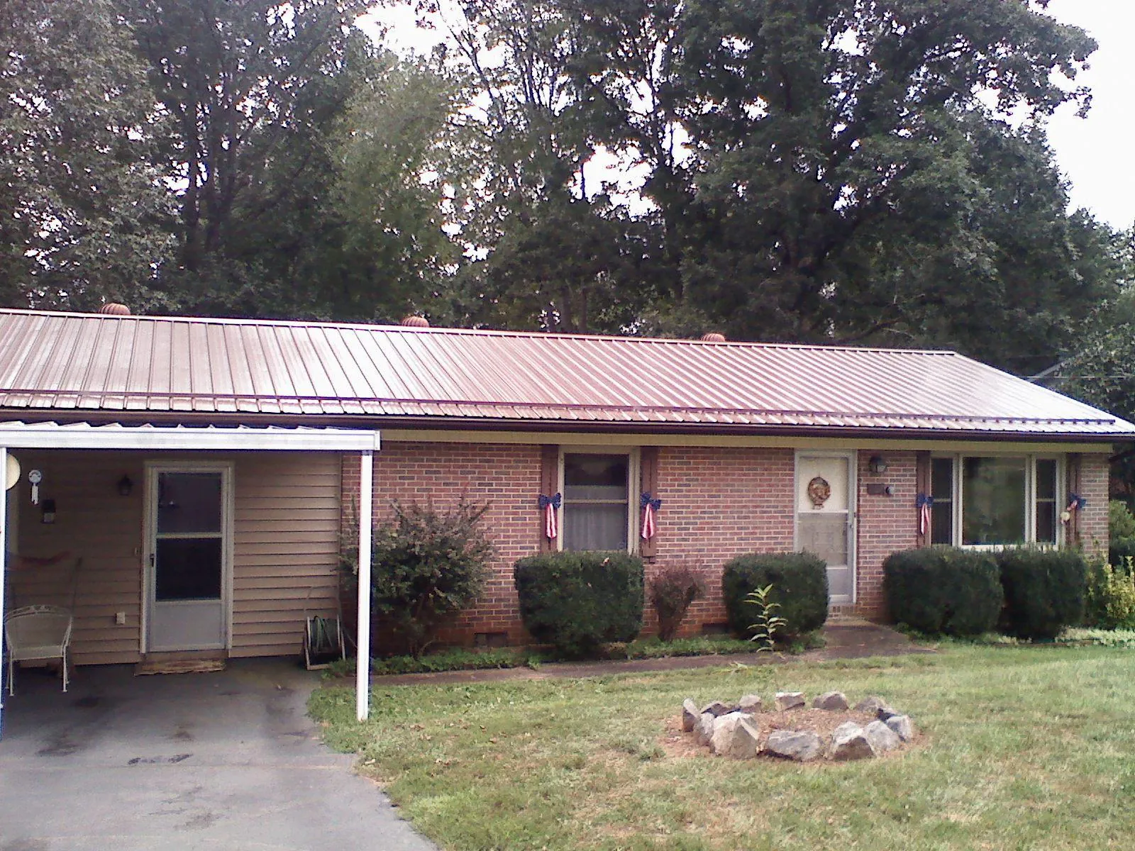 Bronze metal roof and carport on a brick ranch home — Roof Repair work by our crew in Kingston Mines